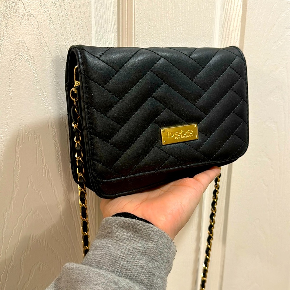 Bebe small, black cross body with gold and black strap.